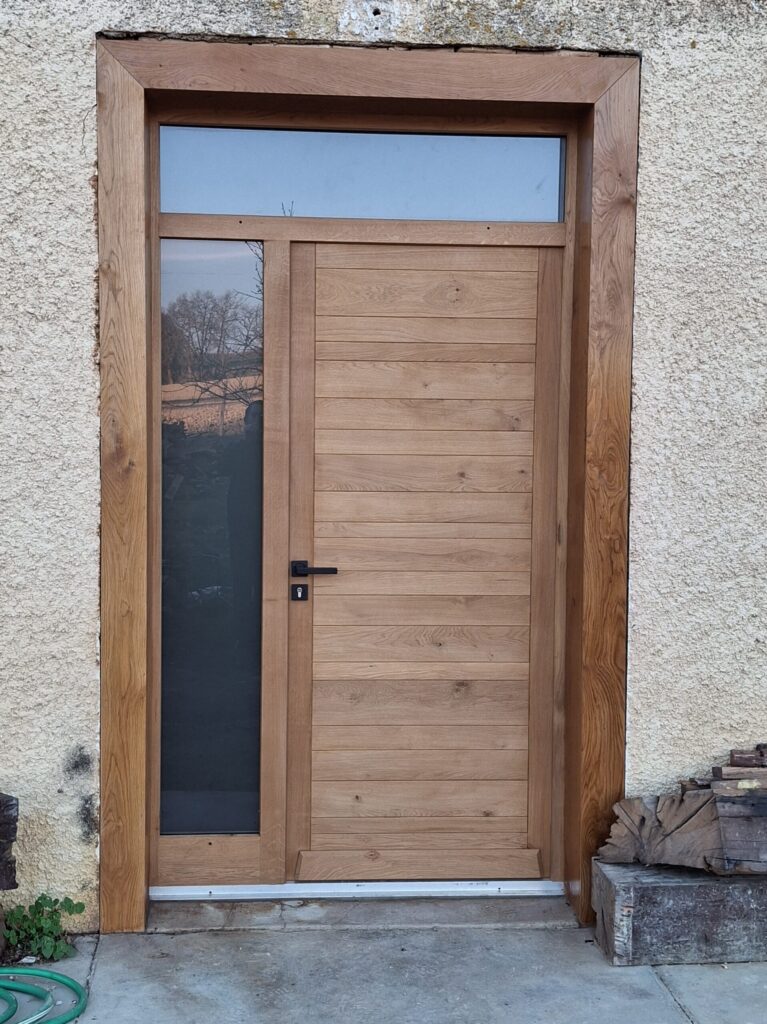 Porte d’entrée en bois clair réalisée par Menuiserie MDB en Occitanie avec éléments vitrés et ambiance rustique,