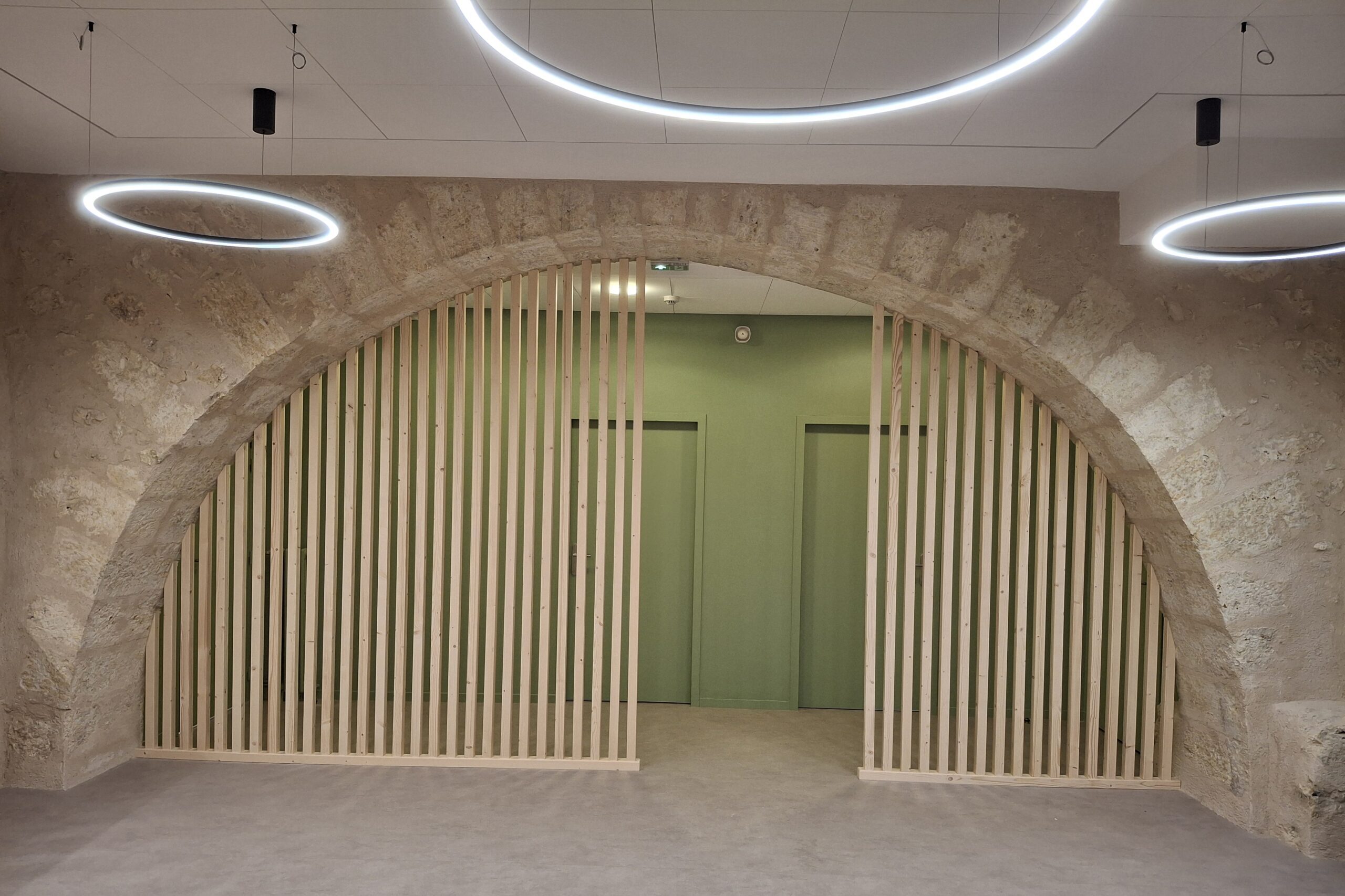 arche en pierre et cloison bois par Menuiserie MDB dans un espace moderne à Occitanie,