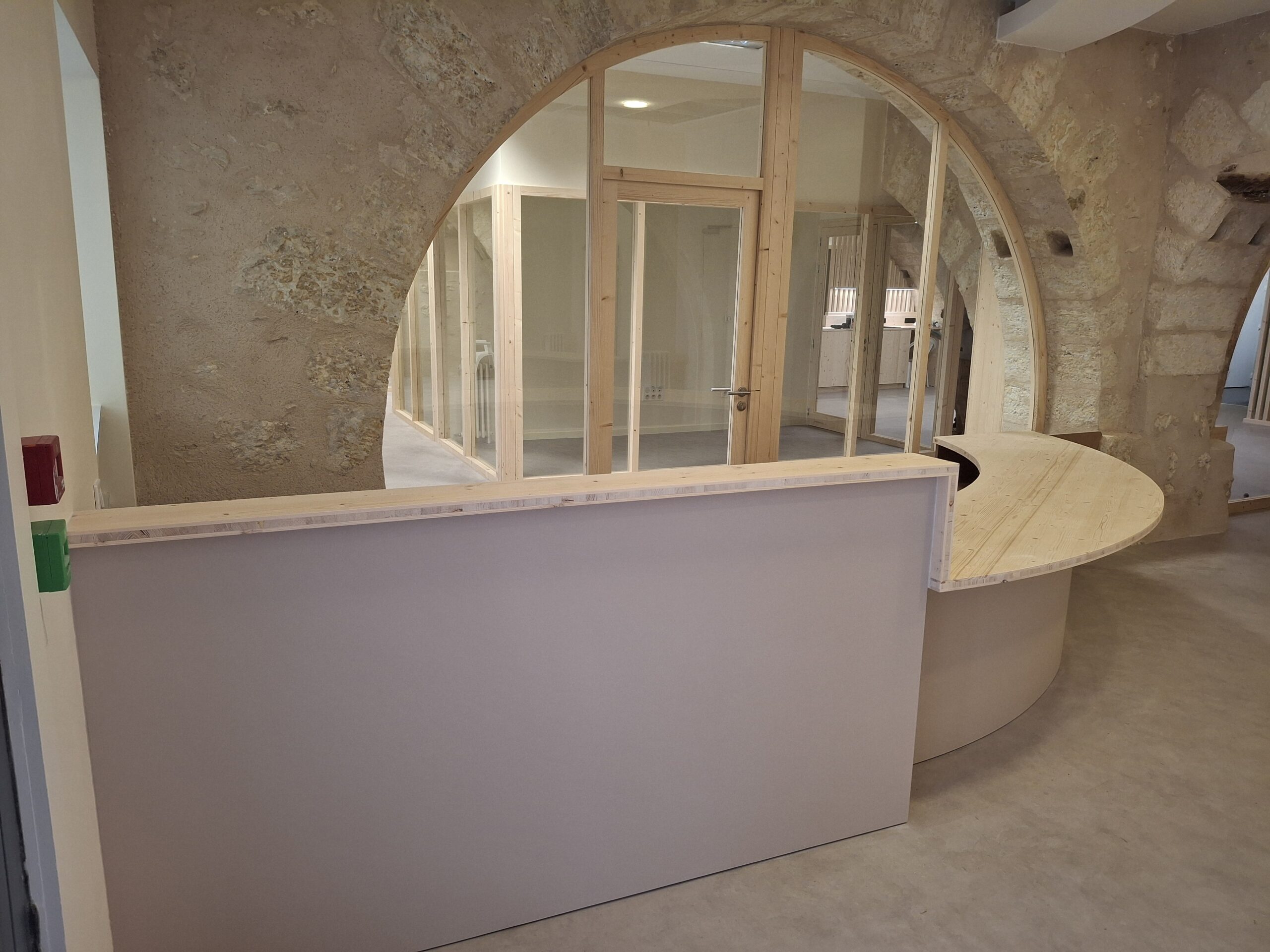 Comptoir en bois clair Menuiserie MDB dans un intérieur pierre et bois à l’accueil en Occitanie,